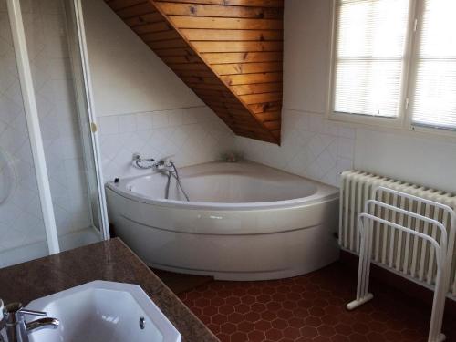 La salle de bains est pourvue d'une baignoire blanche et d'un lavabo. dans l'établissement MAISON EMILIE, à Le Touquet-Paris-Plage