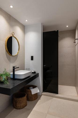 a bathroom with a tub and a sink and a mirror at Abacus Suites in Ayia Napa