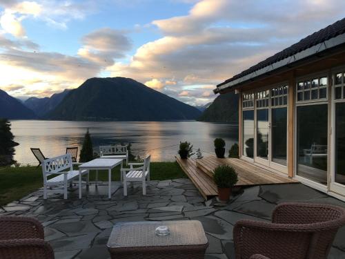 a patio with a view of a lake and mountains at Dragsvik Fjordhotel in Balestrand