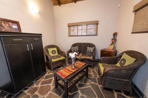 a living room with wicker chairs and a table at Blyde River Wilderness Lodge in Hoedspruit