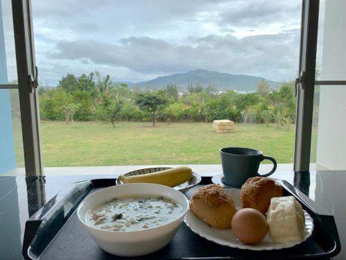 un vassoio con una ciotola di cereali e un piatto di cibo di Kuan Min B&B a Città Vecchia di Hengchun