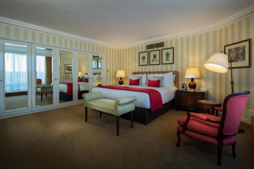a large hotel room with a bed and a chair at Cheval Thorney Court at Hyde Park in London