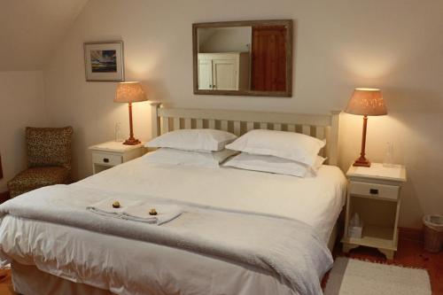 une chambre avec un grand lit blanc avec un miroir dans l'établissement 3 on Roux, à Franschhoek