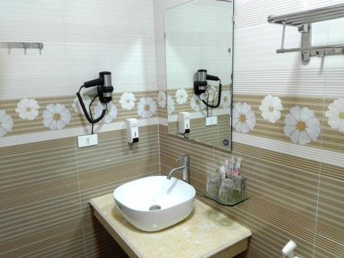 a bathroom with a sink and a mirror at Quoc Thai Sapa Hotel in Sa Pa