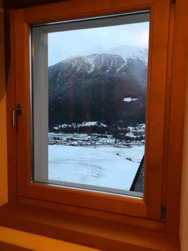 a window with a view of a snow covered mountain at Monolocale Stelvio- Residenza Vallecetta 2 in Bormio
