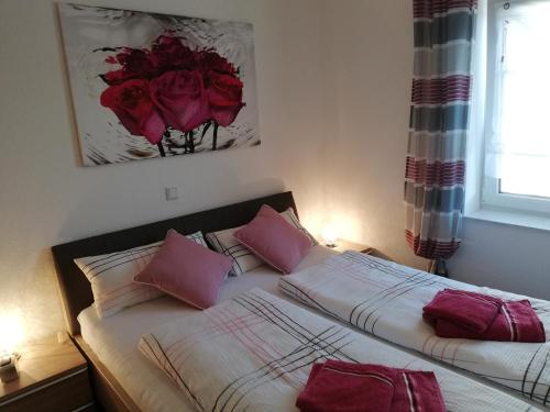 a bedroom with two beds with pink pillows at Residenz Belair Schmidt in Dorum Neufeld