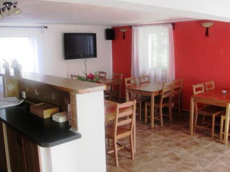 a kitchen and dining room with red walls and tables and chairs at Vila Evička in Sobotka