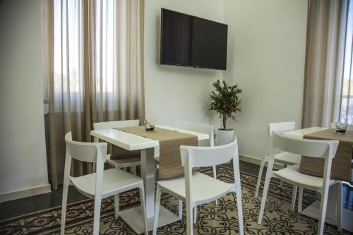 a dining room with a table and chairs and a tv at VILLA ADELAIDE SUITE & ROOM in Torre a Mare