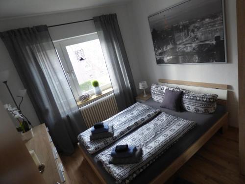 1 dormitorio con cama con almohadas y ventana en Apartmenthaus Geniusbank OL, en Wilhelmshaven