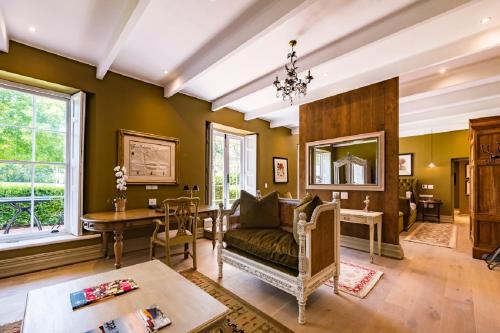 Lanzerac Hotel & Spa في ستيلينبوش: غرفة معيشة مع أريكة وطاولة
