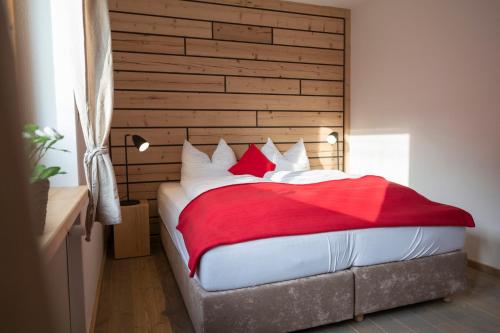 1 dormitorio con 1 cama grande con almohadas rojas y blancas en Kuckucksnester Friedenweiler, en Friedenweiler