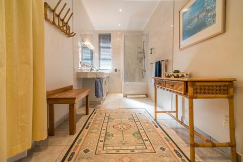 a bathroom with a table and a rug on the floor at Chala-Kigi Apartments in Swakopmund
