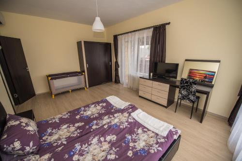 a bedroom with a bed and a desk and a television at Vakarel Residence in Vakarel