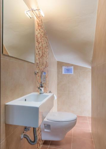 a bathroom with a sink and a toilet and a mirror at Olive Tree House in Gennadi
