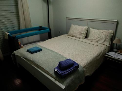 una camera da letto con un letto e due asciugamani di Cozy & Quiet Central Apartment a Kalamáta