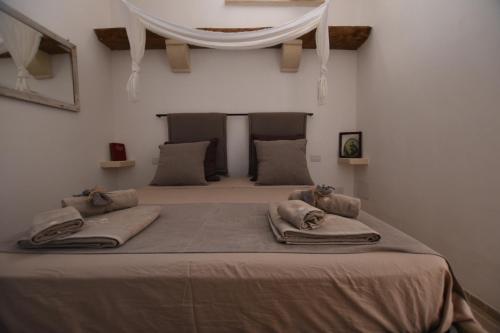 Un dormitorio con una cama grande con almohadas. en Casina Gidò, en Parabita