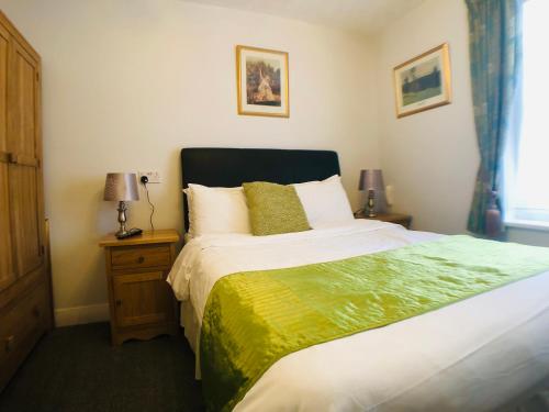 a bedroom with a large bed and two lamps at Ilfracombe House Hotel - near Cliffs Pavilion in Southend-on-Sea