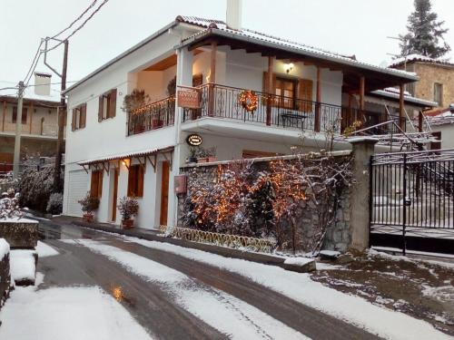 a white house with snow on the street at Zephyros in Vytina