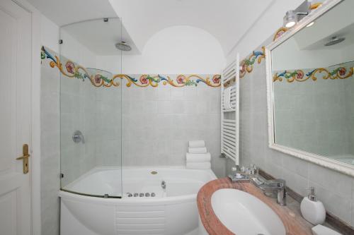 a bathroom with a tub and a toilet and a sink at Villa Yiara in Positano