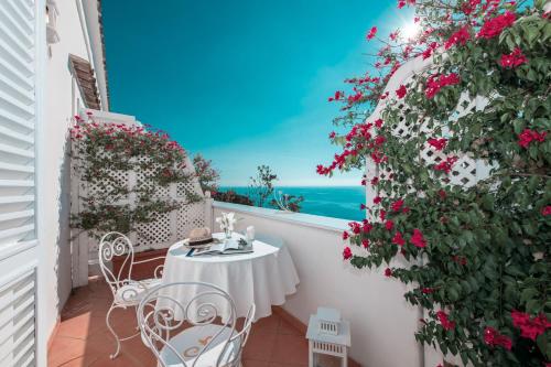 a table and chairs on a balcony with a view of the ocean at Villa Yiara in Positano