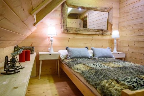 1 dormitorio con 1 cama en una cabaña de madera en Łabowska Chata - Basen, Sauna, Grota solna en Łabowa
