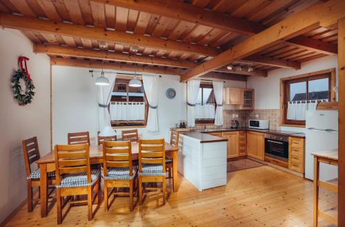 - une cuisine avec des placards en bois, une table et des chaises dans l'établissement Víkendové Chalupy, à Liptovský Trnovec