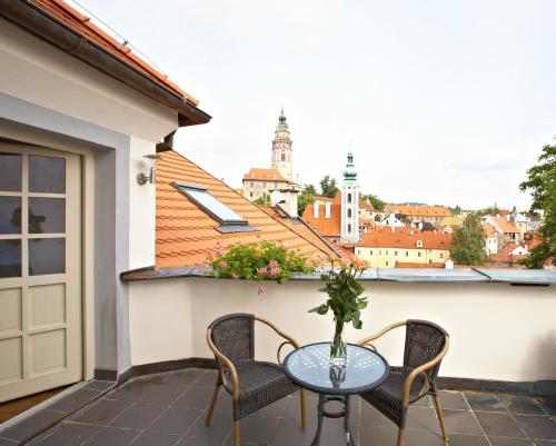 a patio with a table and chairs on a balcony at Hotel Peregrin in Český Krumlov