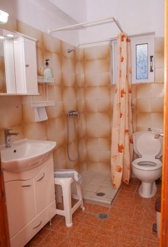 a bathroom with a toilet and a sink at Villa Stamatis in Pefki