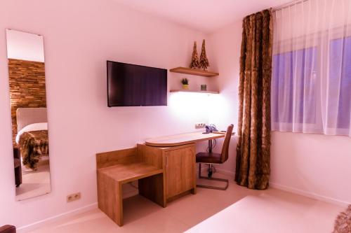 a room with a desk and a bed at ManavaHotel in Herstal