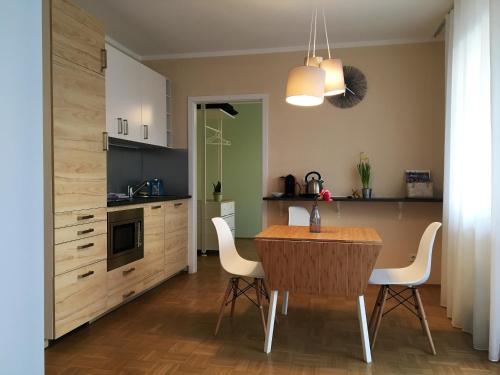 cocina con mesa de madera y sillas blancas en Terrace by BestChoice - FREE Parking - Self Check-in, en Graz