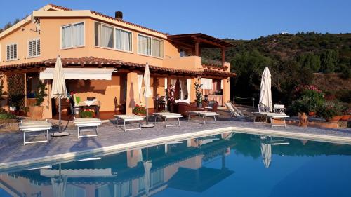 a house with a swimming pool in front of a house at Li Muntigeddi in San Teodoro