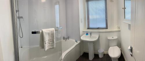 y baño blanco con lavabo y ducha. en Aberdeen Serviced Apartments - Bloomfield, en Aberdeen
