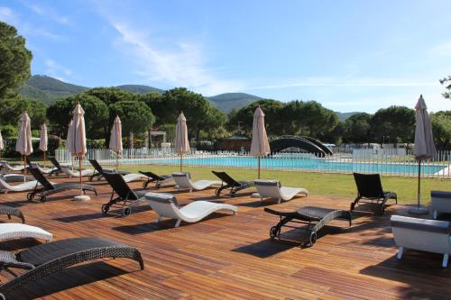 a bunch of chairs and umbrellas next to a pool at Camping Lacona Pineta in Capoliveri