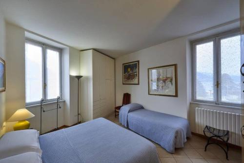 a bedroom with two beds and two windows at Casa Ferry in Varenna