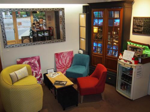 een kamer met stoelen, een tafel en een spiegel bij Hotel Du Croisé in Marcq-en-Baroeul