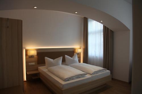 a bedroom with a large bed with white pillows at Schützen Hotel & ConceptStore in Meersburg