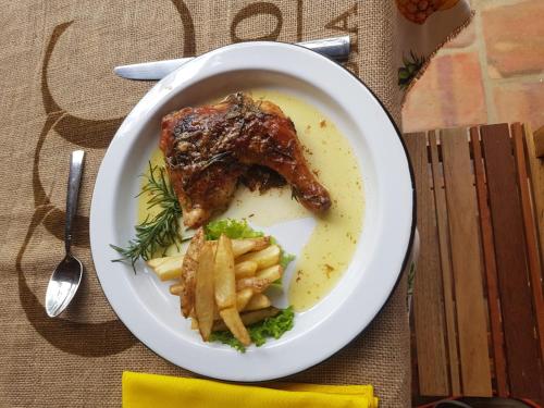 a plate of food with meat and fries on a table at Nativo Glamping in Barichara