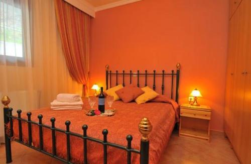 um quarto com uma cama com paredes cor de laranja em Althea em Skala Potamias