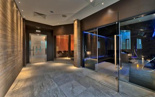 un vestíbulo de oficina con puertas y luces de cristal en Hotel Harrys' Garden, en Abano Terme