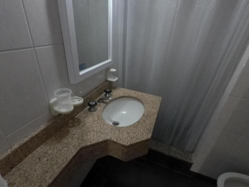 un baño con lavabo y espejo en Hotel Meson, en Pinamar