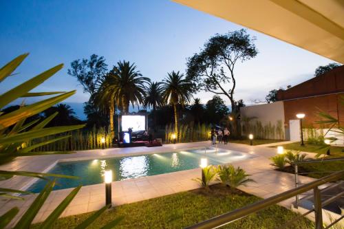 a swimming pool at night with people standing around it at Platinum Hotel Casino in Villa Ángela