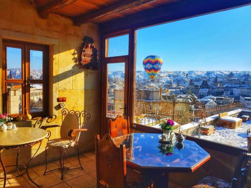 a room with a table and a view of a hot air balloon at Vineyard Cave Hotel in Göreme