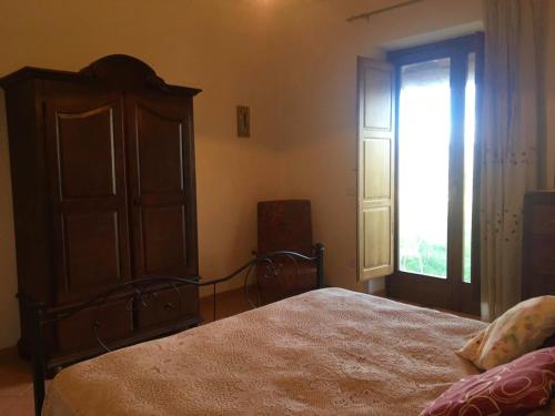 a bedroom with a bed and a dresser and a window at Casa vacanze Il Mandorlo in Perdifumo