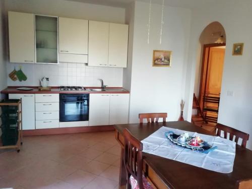 a kitchen with a table and a kitchen with white cabinets at Casa vacanze Il Mandorlo in Perdifumo