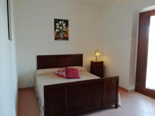 a bedroom with a bed with a red pillow on it at Casa vacanze Il Mandorlo in Perdifumo