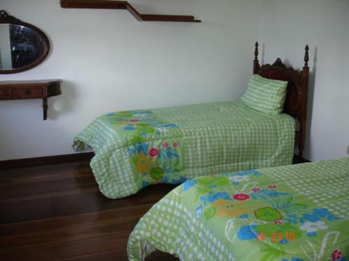 a bedroom with two beds and a mirror at Casa cinematografica em Atibaia in Atibaia