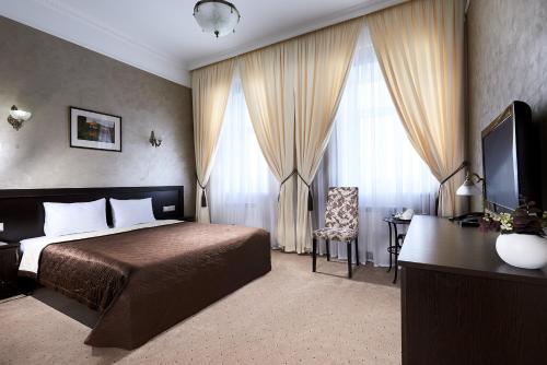 Un dormitorio con una cama, un escritorio y un televisor. en Hotel Imperial Wellness & SPA, en Obninsk