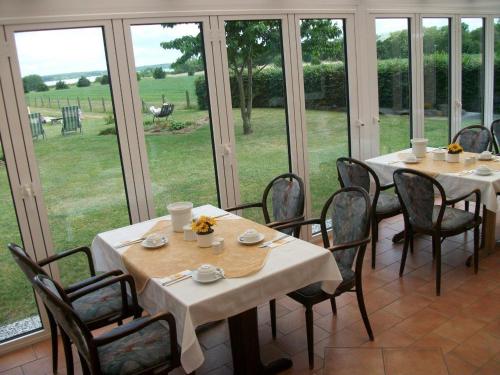 a dining room with tables and chairs and windows at Hotel Marianne und Restaurant Kiek In in Plau am See