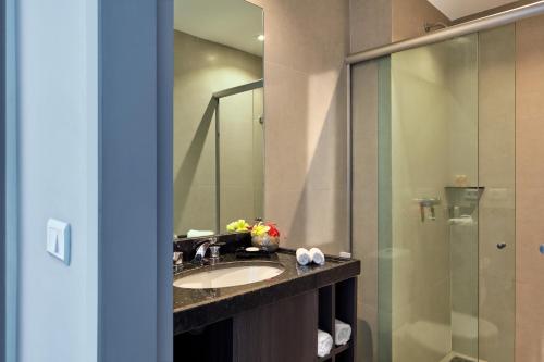 a bathroom with a sink and a glass shower at Rox Hotel in Jericoacoara