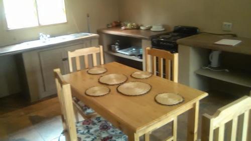 a kitchen with a wooden table with plates on it at Rugare Sweet Dreams Holiday Cottage in Curryʼs Post
